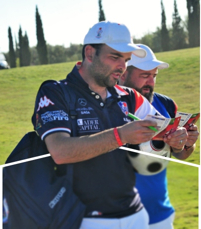 Close-up of two men reviewing scorecards on a golf course.